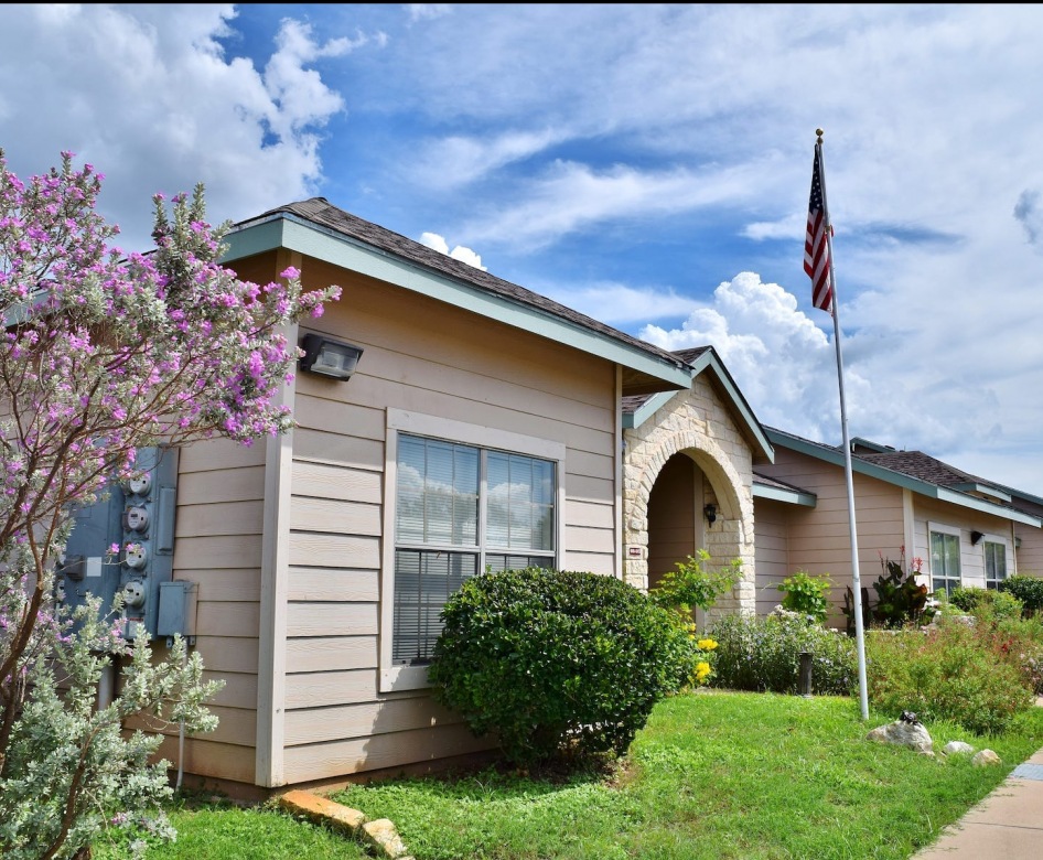 outside entrance to property showing some landscaping and spacious sidewalks