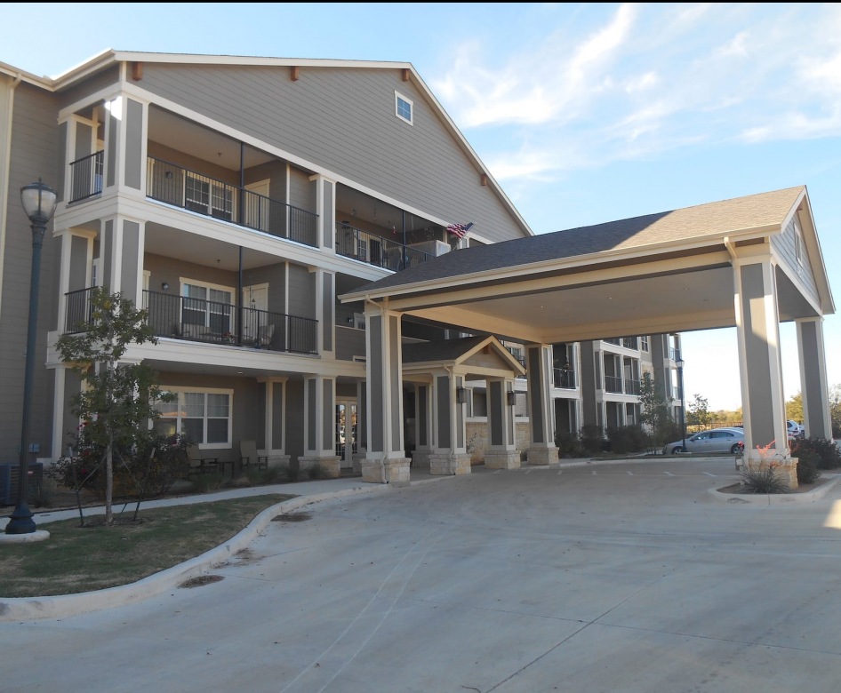 outside entrance to property showing some landscaping and spacious sidewalks